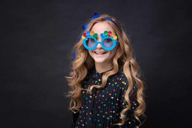 Portrait cute playful dreamy with toothy smile beautiful girl fooling around in blue glasses with th...