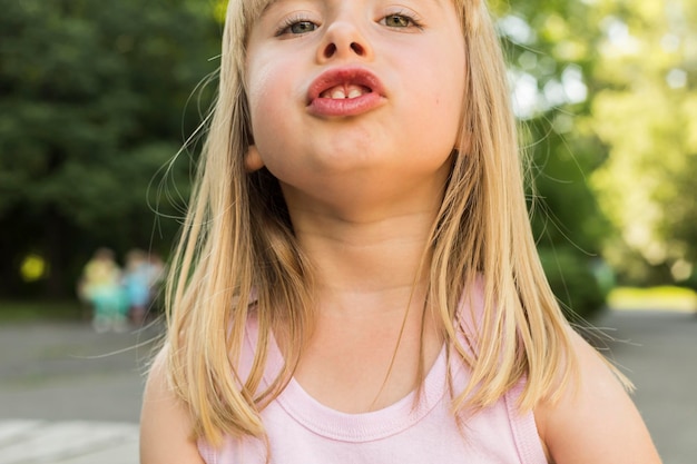 Photo portrait of cute playful girl at road