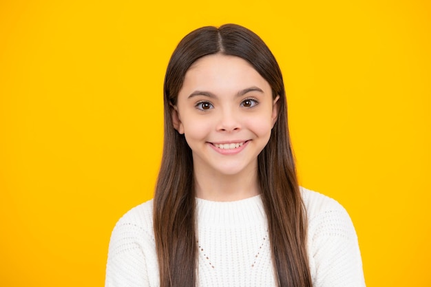 Portrait of cute positive little girl isolated on yellow background attractive caucasian child smiling and looking at camera