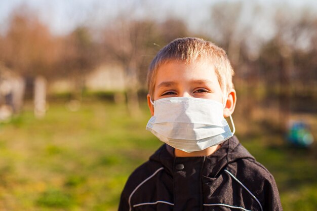 Ritratto di un bambino in età prescolare carino che indossa una maschera medica un ragazzo che indossa una maschera per la bocca contro illnes concetto di quarantena del coronavirus o misure antiepidemiche covid19