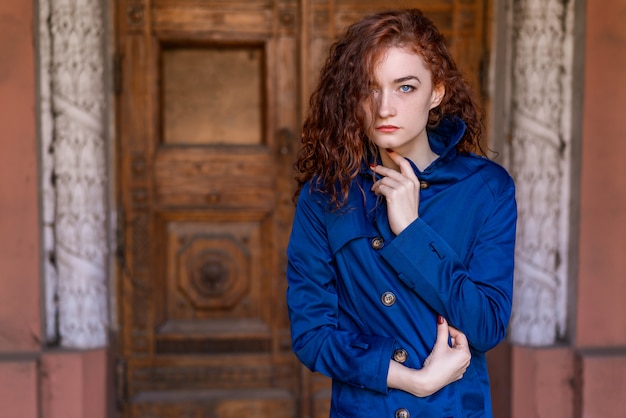 Portrait of cute red-haired girl , wavy hair and beautiful eyes