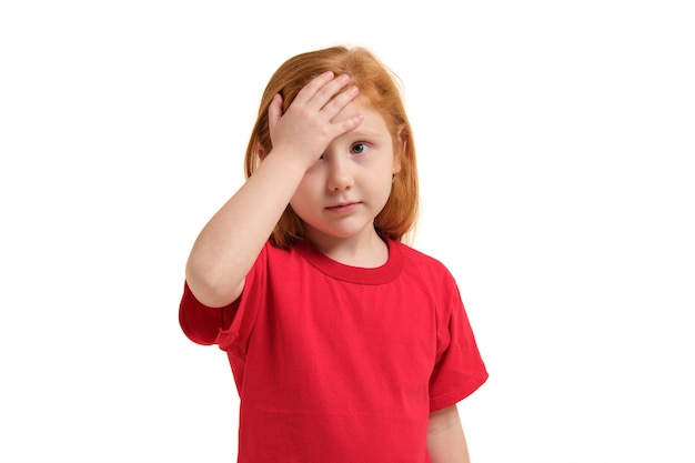 Ritratto di una bambina emotiva rossa carina che fa il palmo in faccia isolata su un bianco