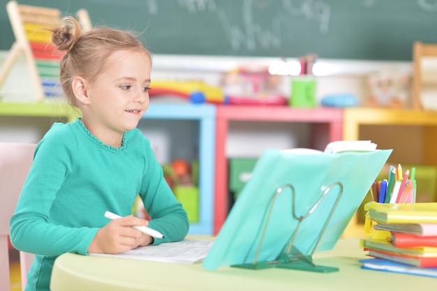 Portrait of a cute schoolgirl doing homework