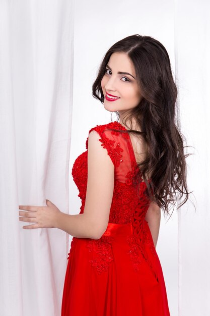 Portrait of cute sexy beautiful woman in red dress over white background