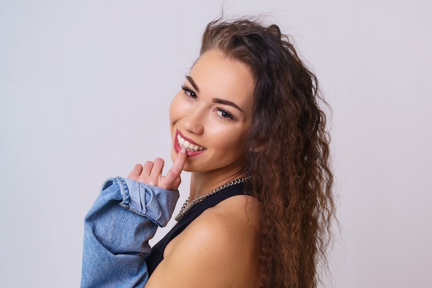 Portrait of a cute and shy young woman smiling young caucasian woman posing on a light background in...