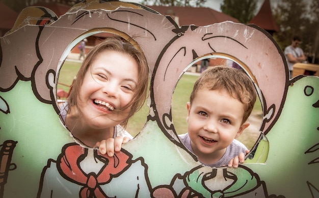 portrait of cute sibling peeking through cutout