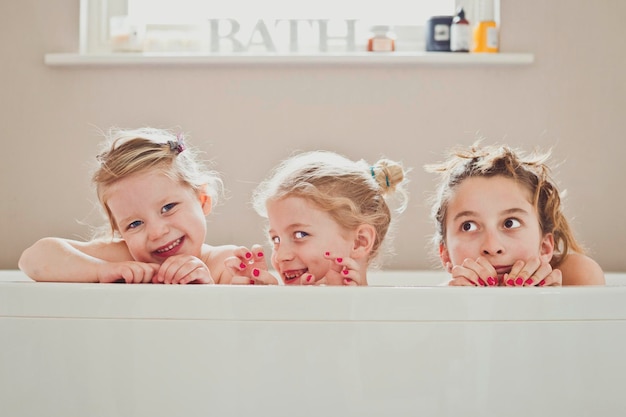 Photo portrait of cute siblings in bathtub at home