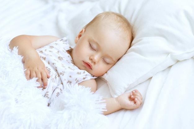 침대에서 귀여운 잠자는 아기 소녀의 초상화
