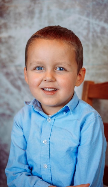 Photo portrait of a cute smiling boy in a blue shirt       person
