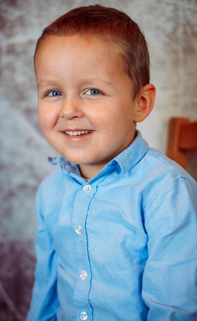 Photo portrait of a cute smiling boy in a blue shirt        person