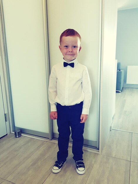 Photo portrait of cute smiling boy standing at home