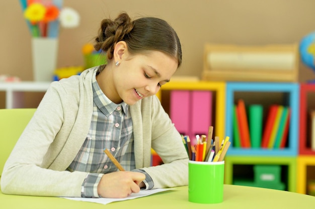 Portrait of cute smiling girl drawing at home