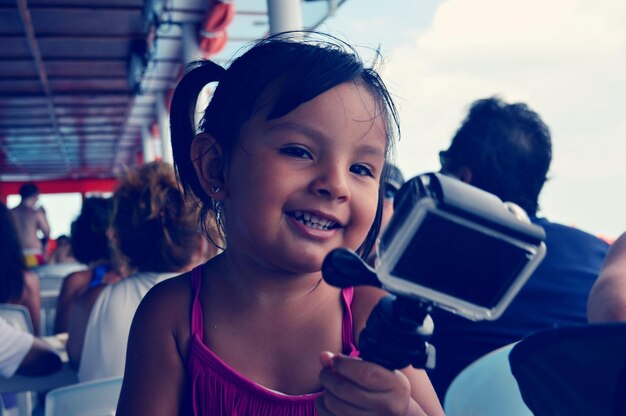 Foto ritratto di una ragazza sorridente e carina che tiene in mano la fotocamera