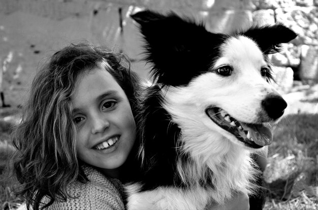 Photo portrait of cute smiling girl with dog in yard