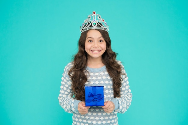 Portrait of cute smiling little girl with gift box kid in princess crown happy birthday daughter Birthday Princess Kid silver crown symbol of glory portrait of pride happy childrens day