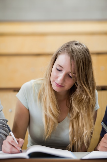 Photo portrait of a cute student writing on a notepad