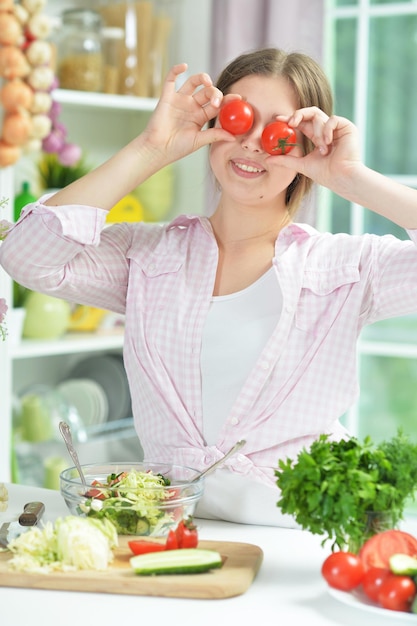 Portrait of cute teen girl having fun while cooking