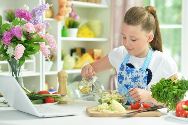 Portrait of cute teen girl preparing fresh salad