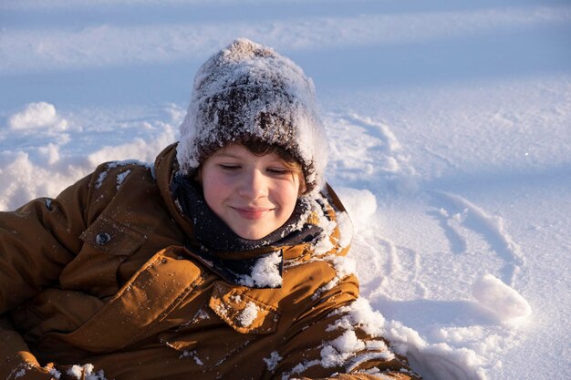 冬の自然の中で雪で覆われた帽子で雪で遊んでいる可愛いティーンエイジャーの肖像画