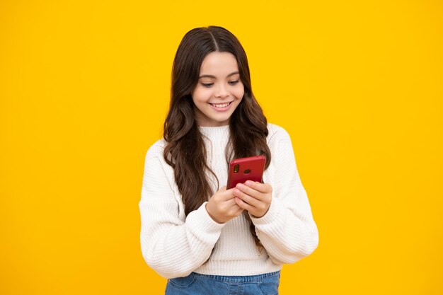 Portrait of cute teenage girl using mobile phone chatting on web typing sms message mobile app for smartphone children lifestyle concept mock up copy space happy face