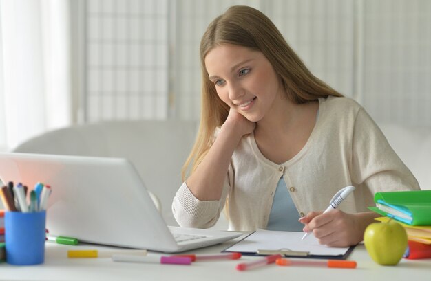 Photo portrait of a cute teenager girl using computer