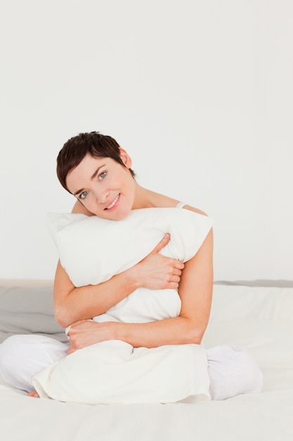 Portrait of a cute woman holding a pillow