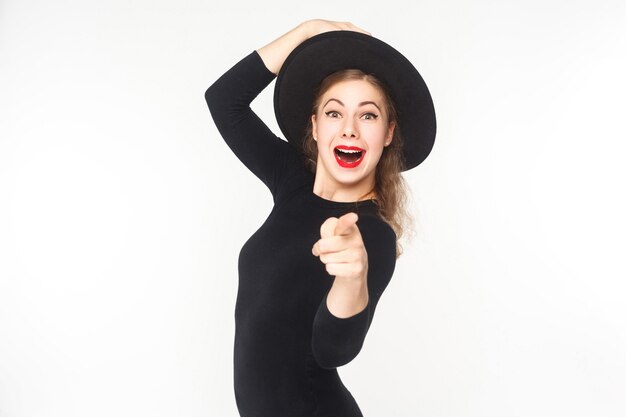 Portrait of cute woman, pointing fingers at camera, open mouth. Studio shot, isolated on white background