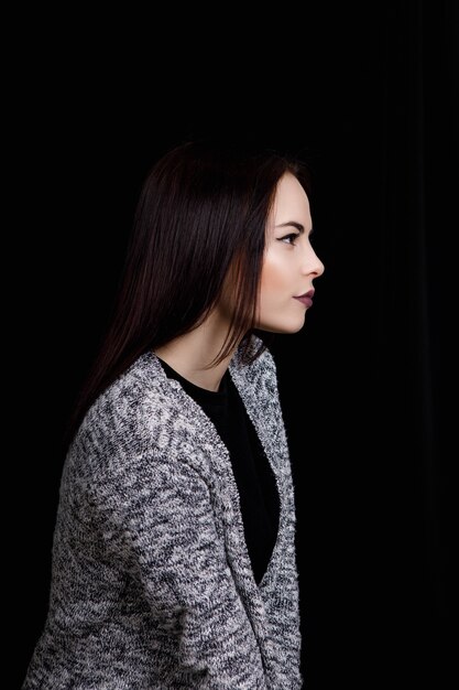 Portrait of cute woman which is looking to the side Full face on a black background