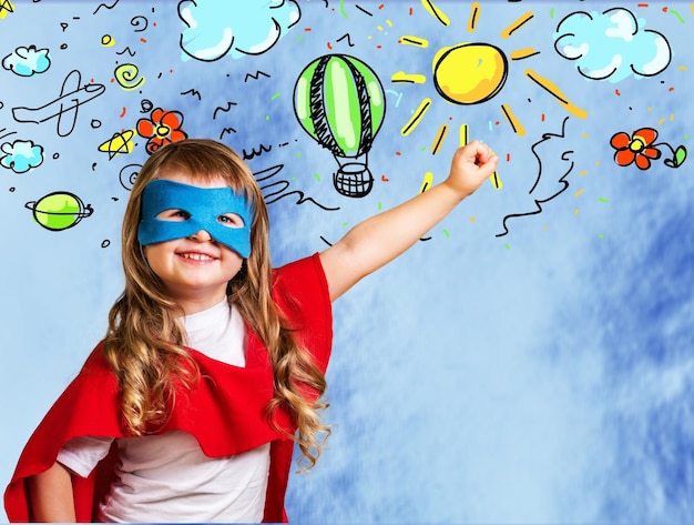 Portrait of cute young boy in mask thinking over blue background