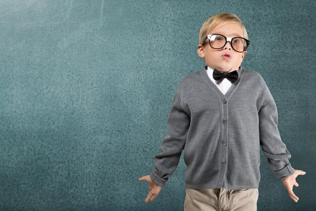 Portrait of a cute young boy with glasses isolated on  background. Studio shot.