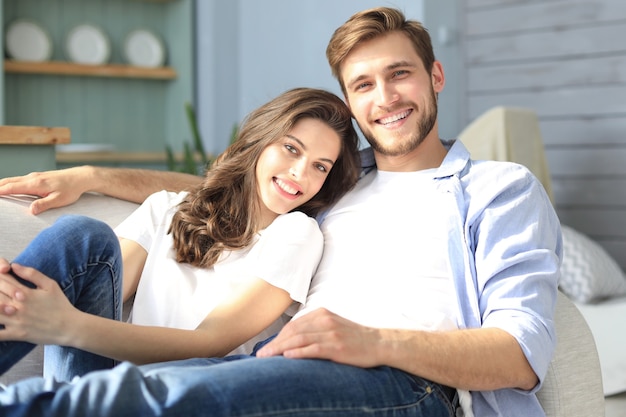 Portrait of cute young couple sitting in sofa.