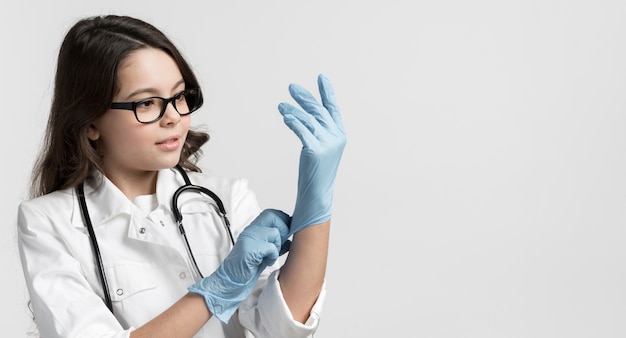 Photo portrait of cute young girl with surgical gloves