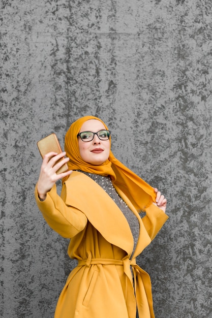 Portrait of cute young woman taking a selfie