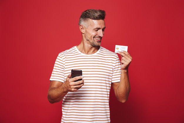 Portrait of a delighted man standing on red