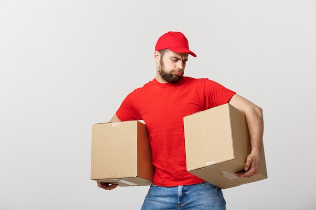 Portrait delivery man in cap with red t-shirt working as courier or dealer