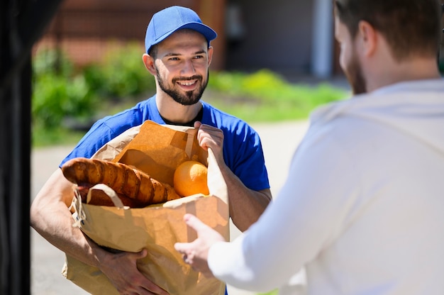 Portrait of delivery man handing out groceries