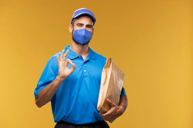 Photo portrait of delivery man holding paper parcel