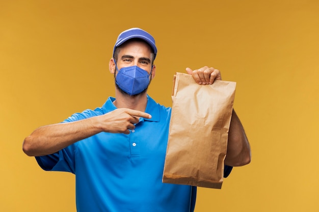 Photo portrait of delivery man holding paper parcel
