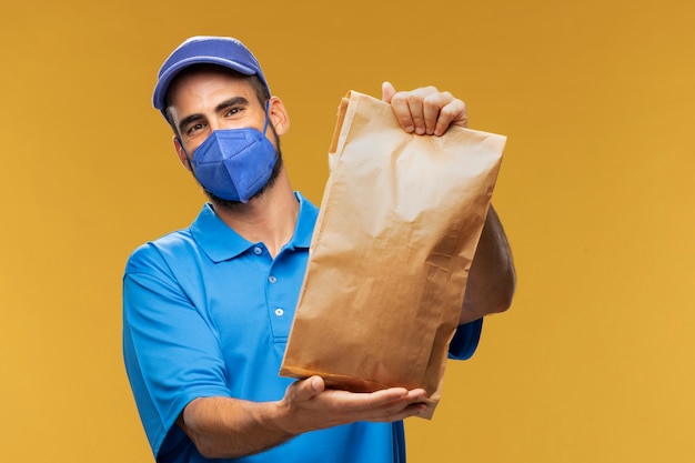 Photo portrait of delivery man holding paper parcel