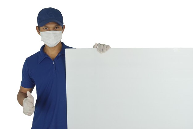 Portrait of delivery man wearing medical mask and medical gloves holding blank billboard on white