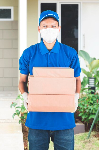 Portrait of delivery person holding parcel standing outdoors