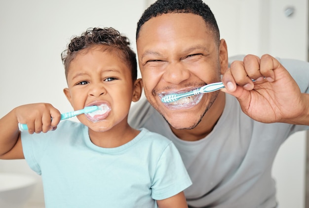 Portrait of dental dad kid brushing teeth and healthy mouth cleaning in home bathroom Happy father teaching child oral healthcare wellness and fresh breath with toothbrush toothpaste and smile