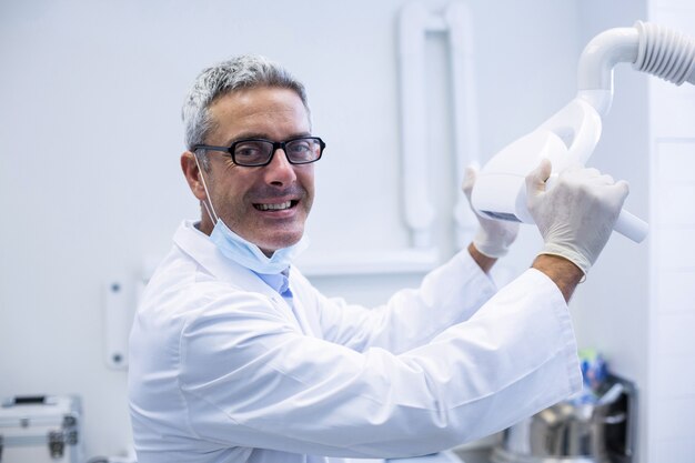 Portrait of a dentist adjusting light