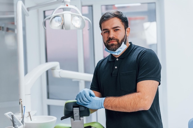 Portrait of dentist in gloves that standing indoors in the clinic.