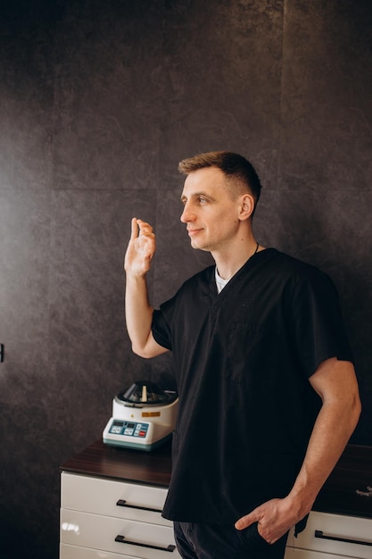 Portrait of a dentist holding aligners in his hand