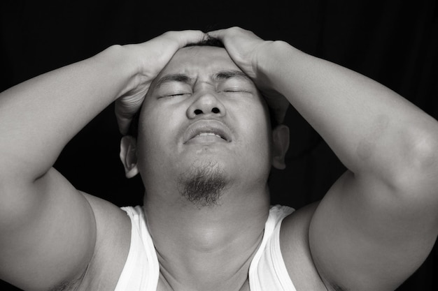 Portrait of depressed Asian male in black and white