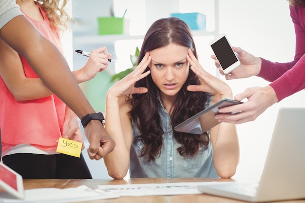 Portrait of depressed businesswoman with head in hands 