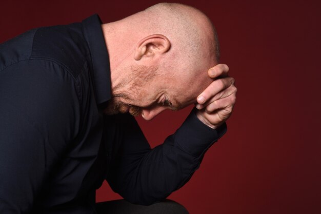 Portrait of a desperate man on red background