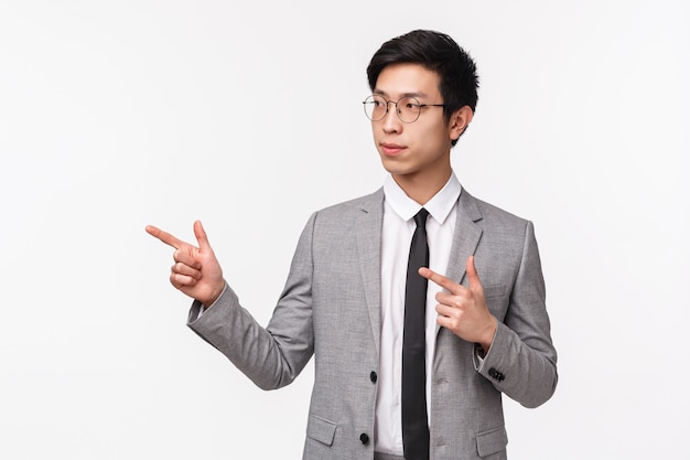 Портрет решительного умного бизнесмена, азиатского парня в сером костюме