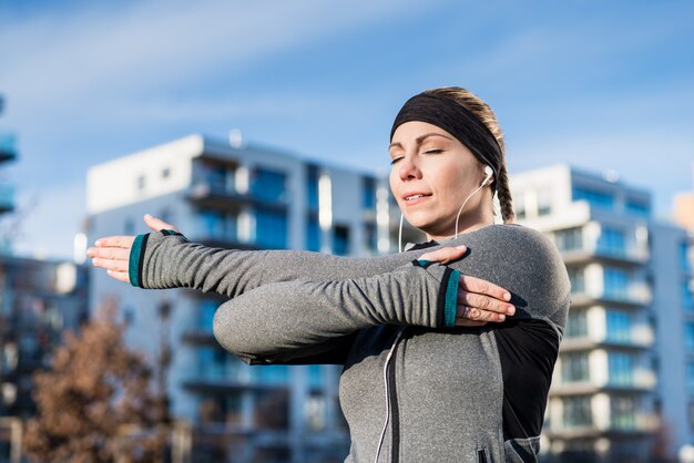 Portrait of a determined young woman stretching her left arm